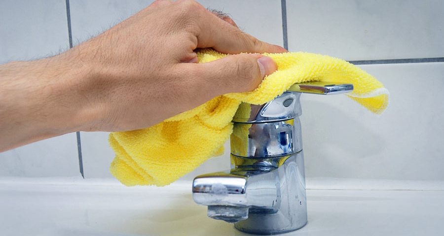 A person is washing their hands with yellow cloth