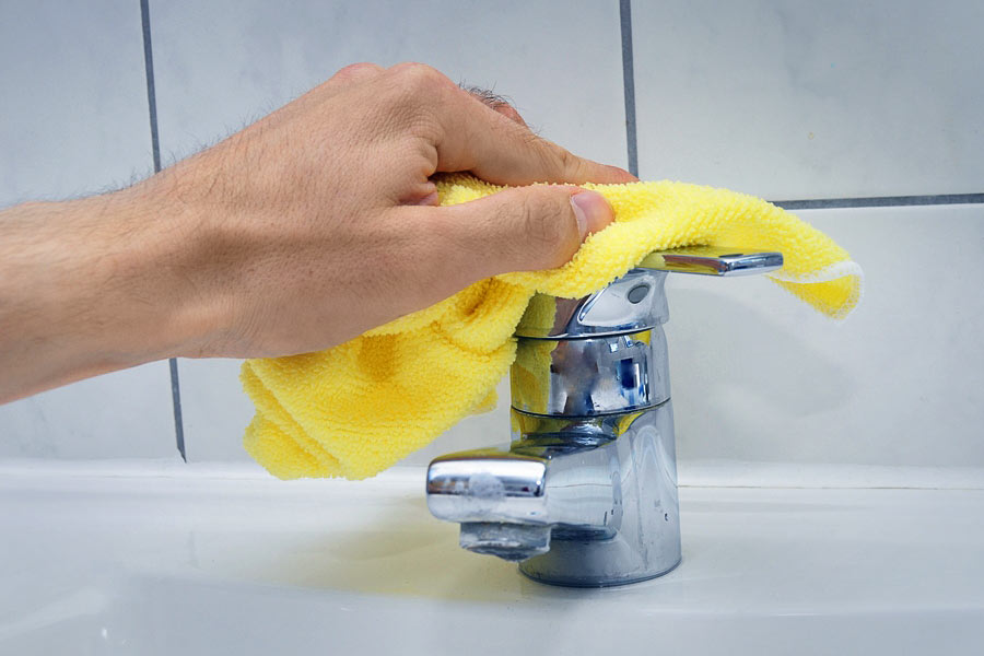 A person is washing their hands with yellow cloth
